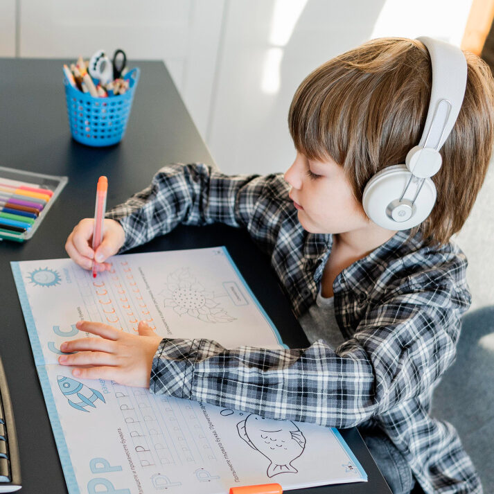 Student writing at a desk during a classroom learning activity.