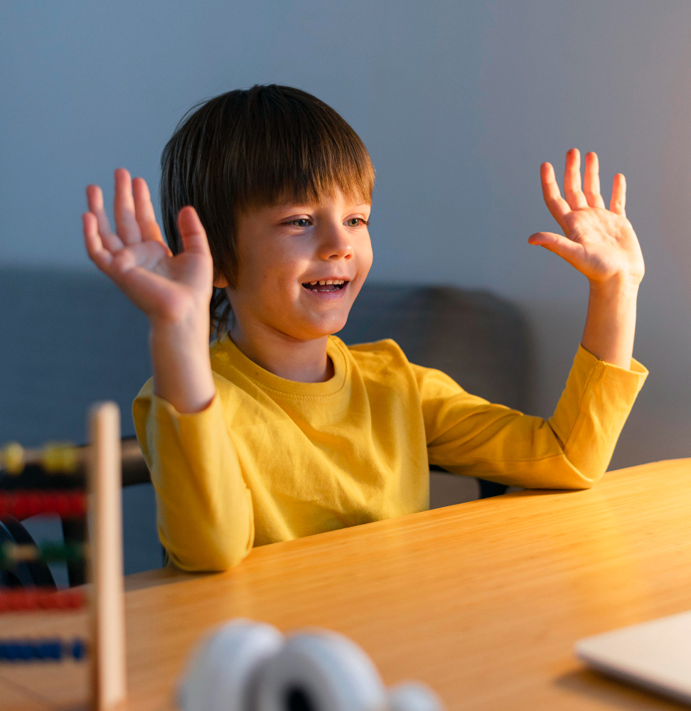 Student raising both hands while participating in a classroom lesson.