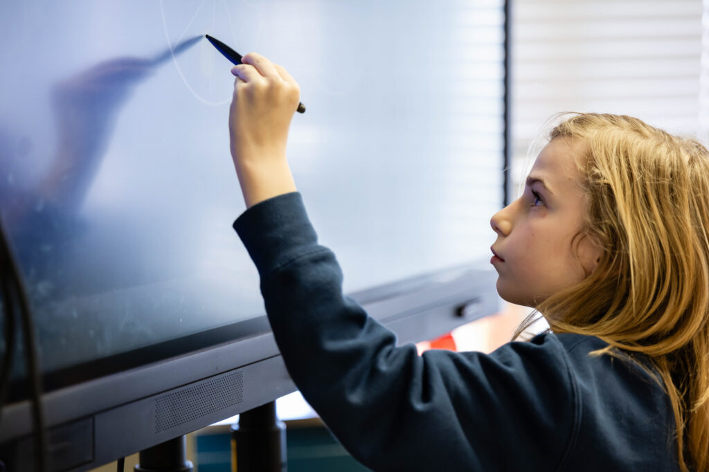 Student using an interactive classroom display during a lesson at Horizon Academy.