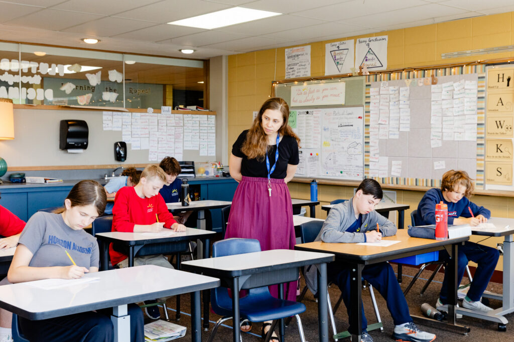 Teacher leading an intermediate school classroom discussion.