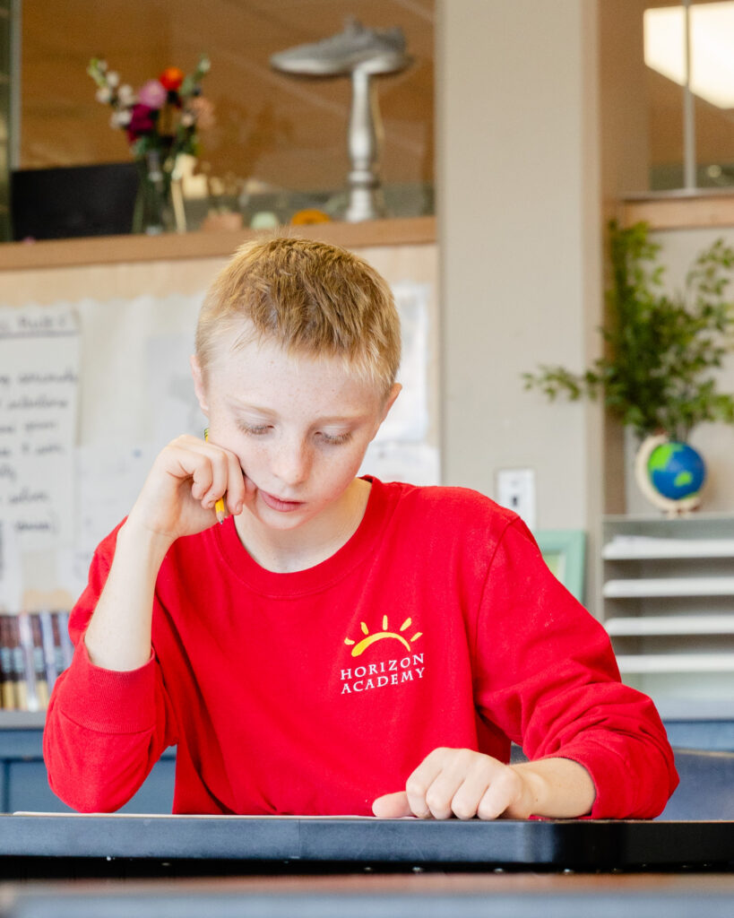 Intermediate school student concentrating on a classroom assignment.
