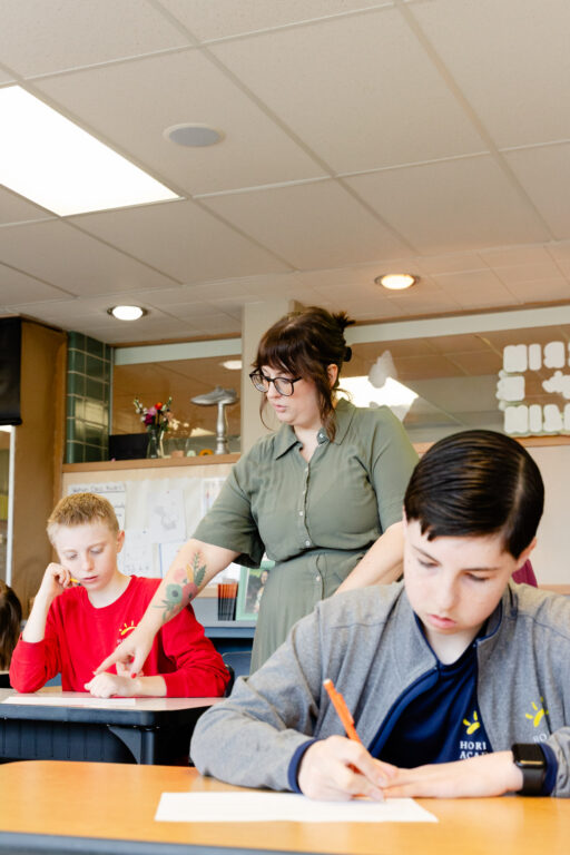 Teacher providing individualized support to an intermediate school student during class.