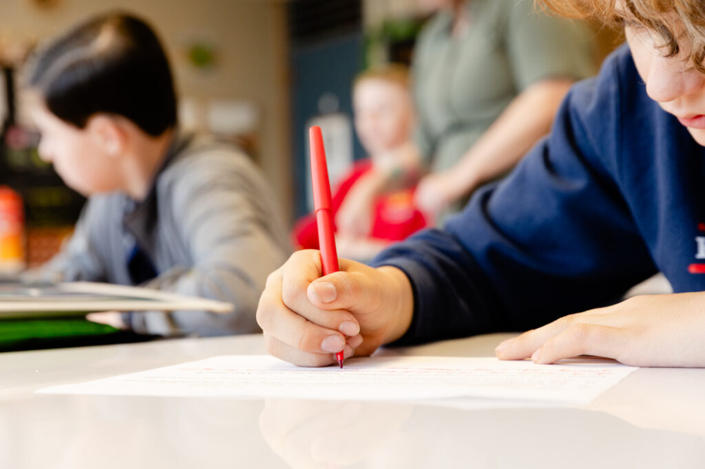 Intermediate school student completing a classroom writing assignment.