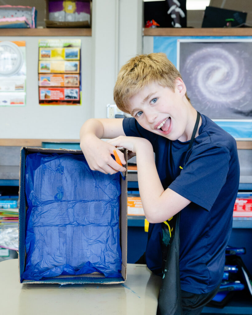 Lower school student engaged in a classroom learning activity with instructional materials.