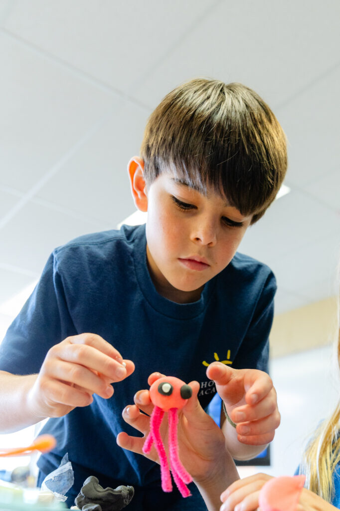 Lower school student concentrating on a hands-on classroom project.