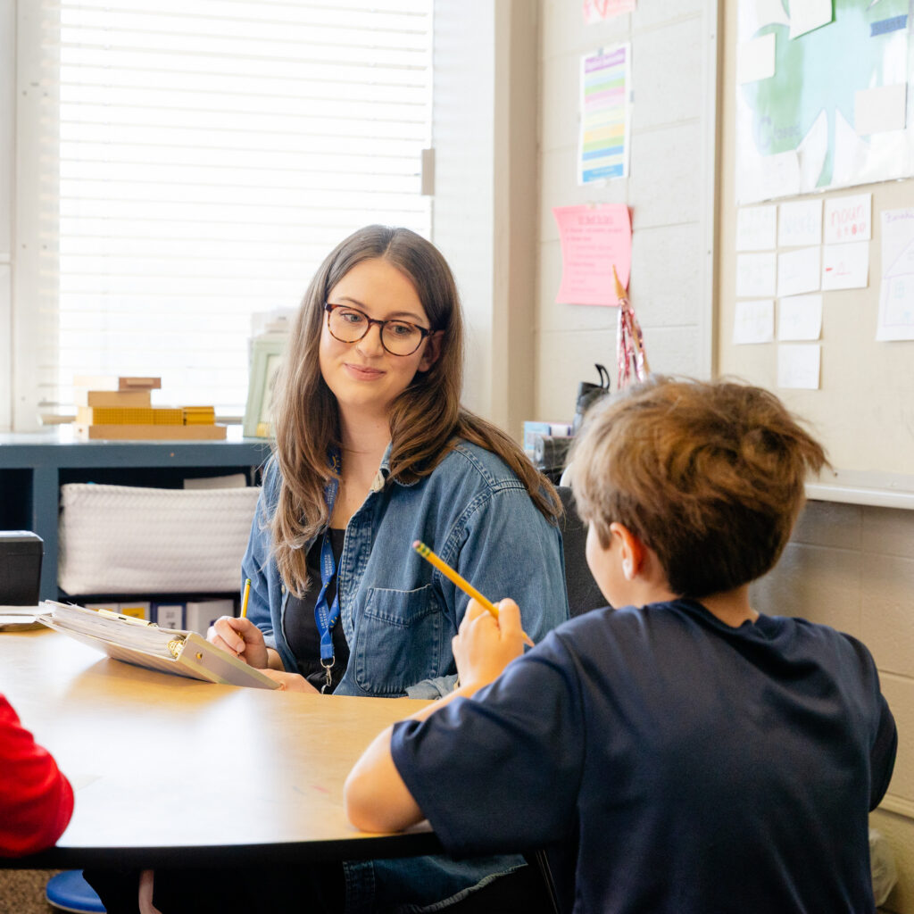 Teacher providing individualized instruction to a lower school student.