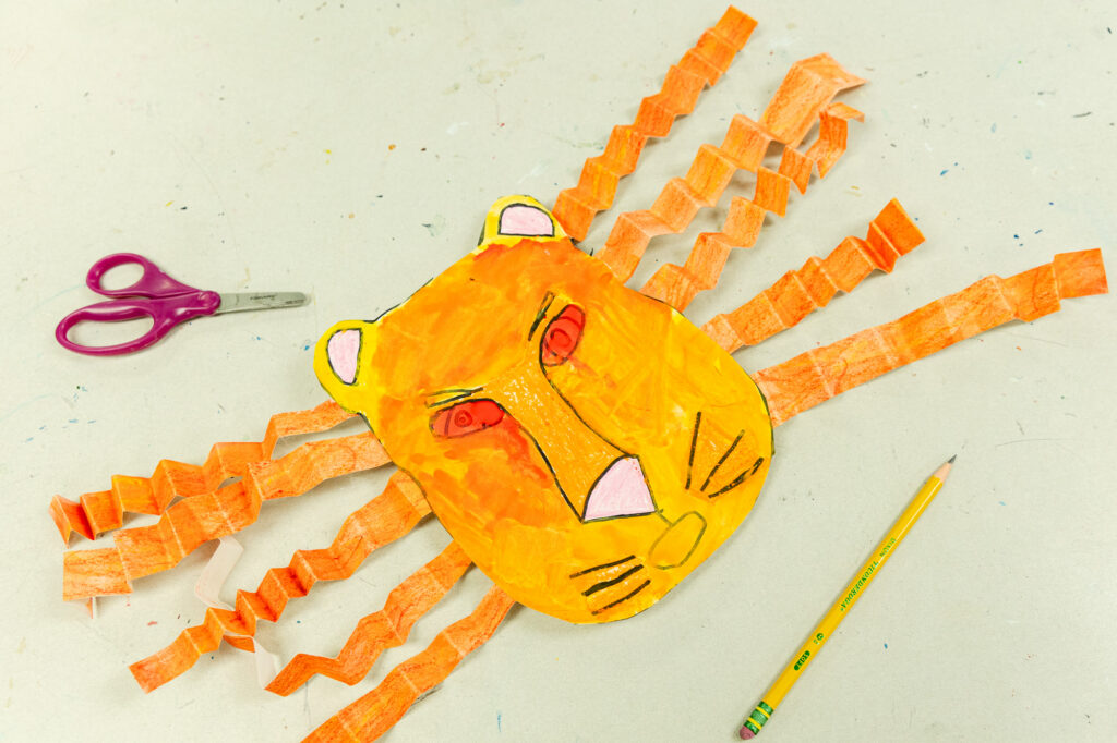 Student artwork featuring a painted handprint and craft project.