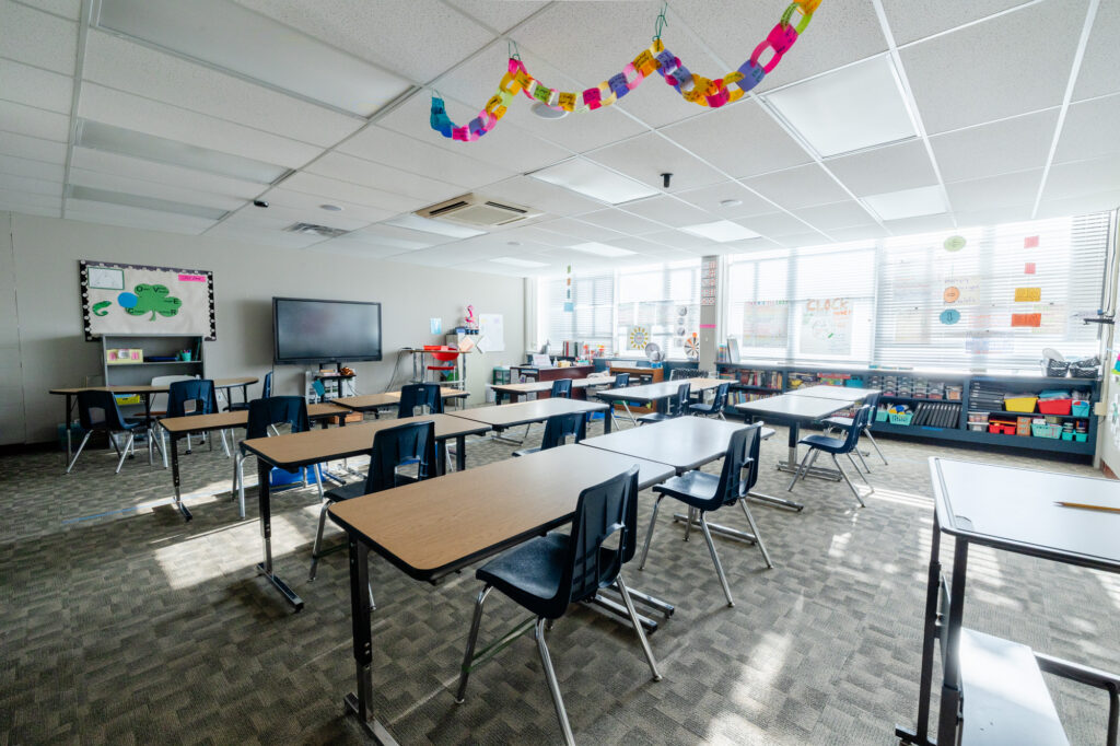 Open classroom with student worktables and colorful ceiling decorations at Horizon Academy.