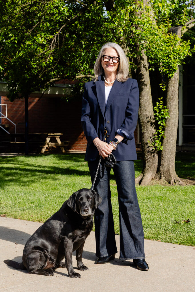 Staff member standing outdoors with a service dog during a morning meeting at Horizon Academy.