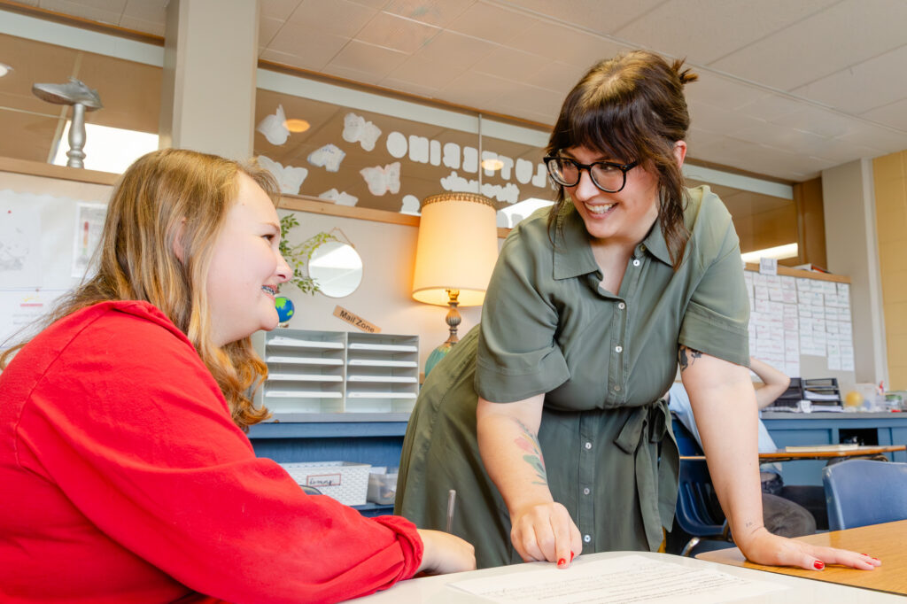 Teacher providing one-on-one support to a middle school student.