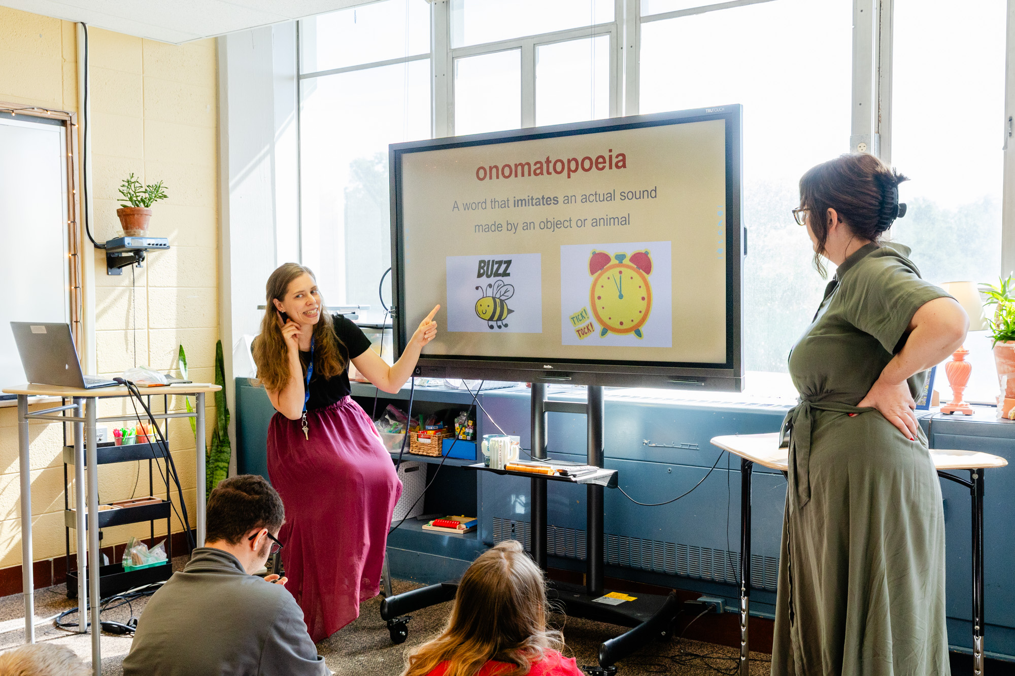 Teacher leading a middle school classroom lesson using a large interactive display.