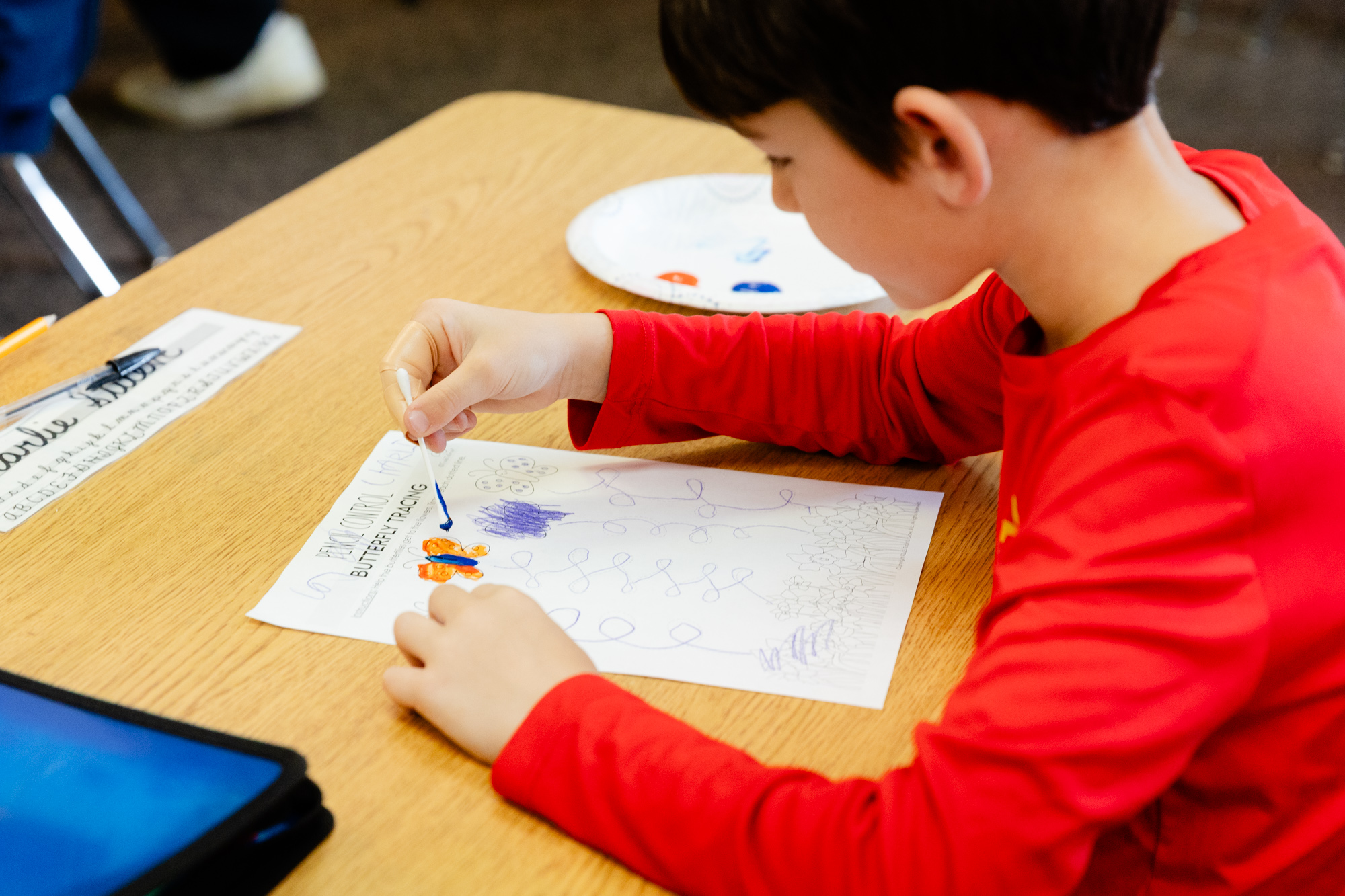 Student practicing handwriting during an occupational therapy session.