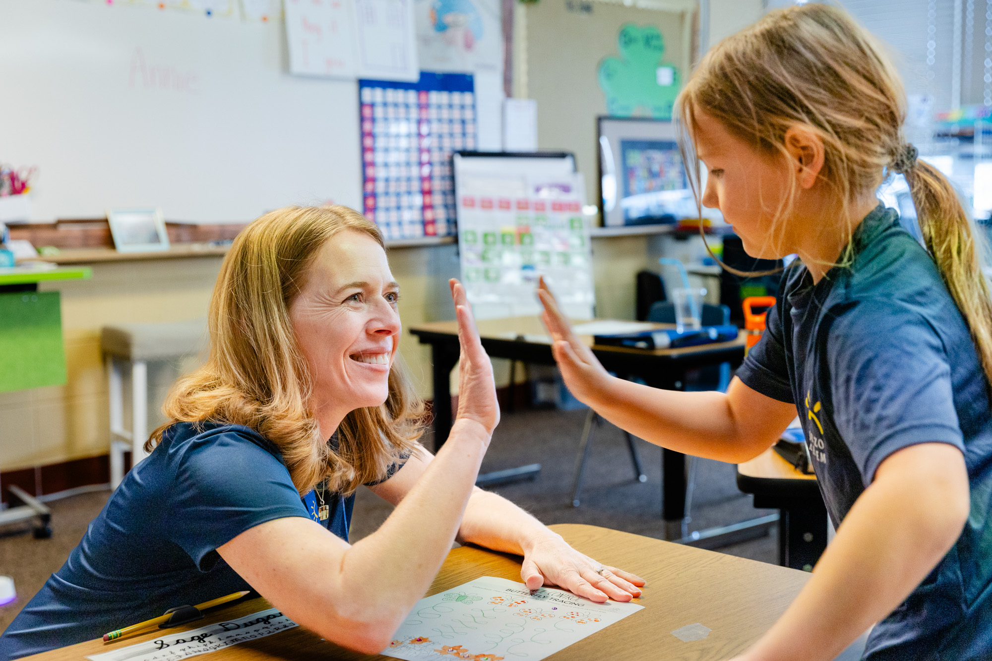 Occupational therapist assisting a student with a fine motor skills activity.