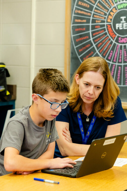 Occupational therapist supporting a student during a learning activity.