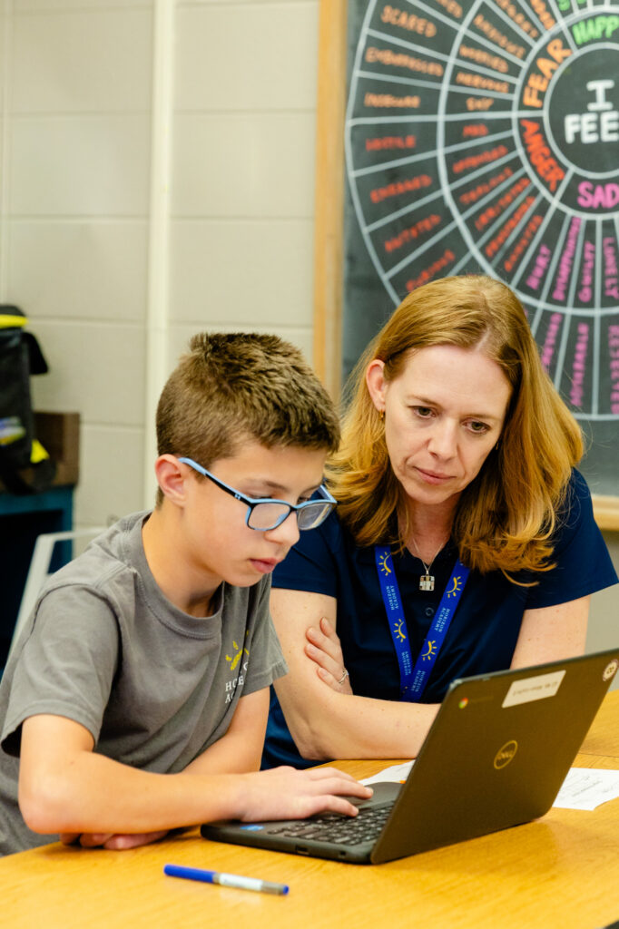 Occupational therapist supporting a student during a learning activity.
