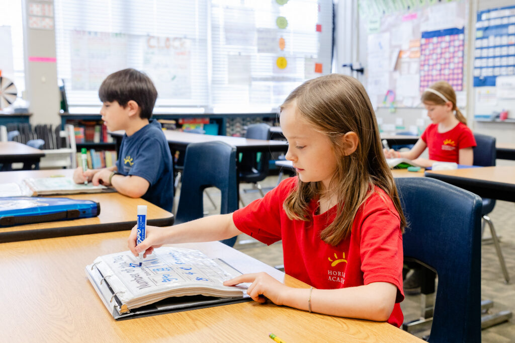 Student working independently at a classroom desk during a lesson.
