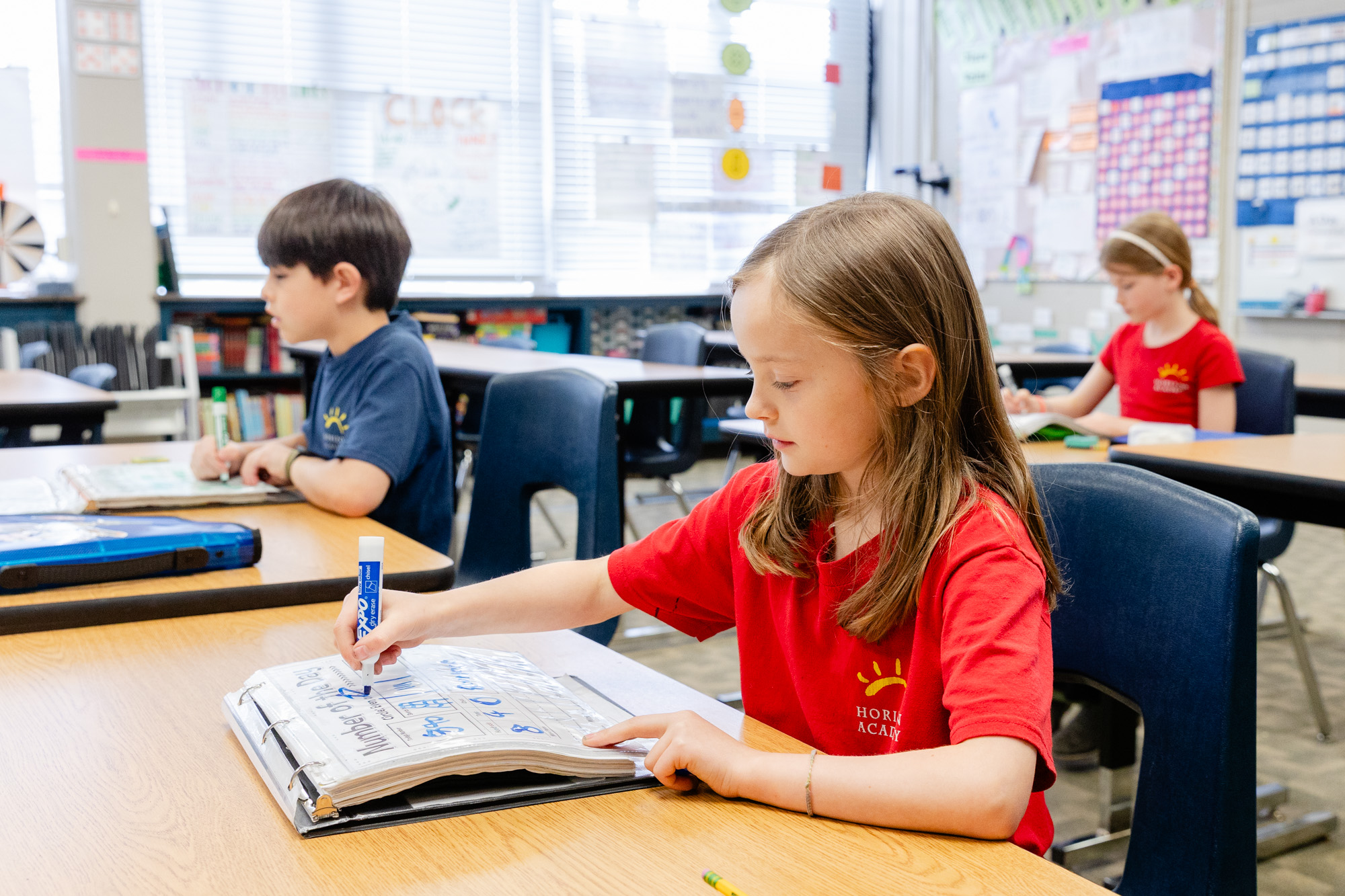 Student working independently at a classroom desk during a lesson.