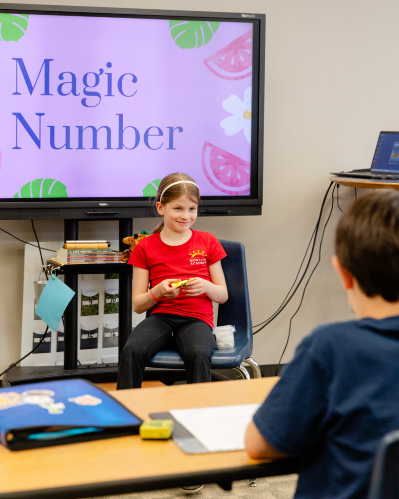 Teacher leading a math lesson using a classroom display at Horizon Academy.