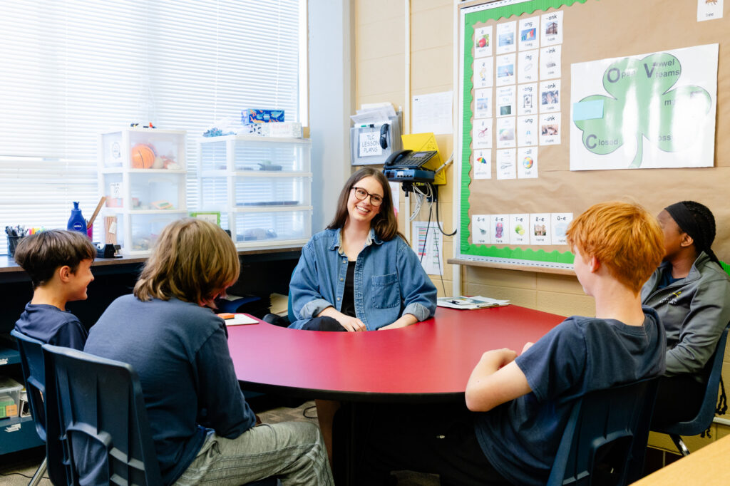 Educator leading a small-group discussion with students at Horizon Academy.
