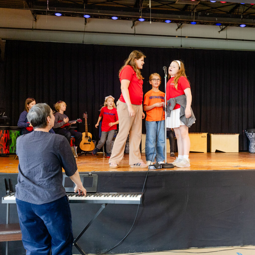 Students participating in a stage performance at Horizon Academy.