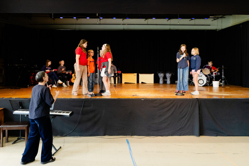 Students performing on stage during a school presentation at Horizon Academy.