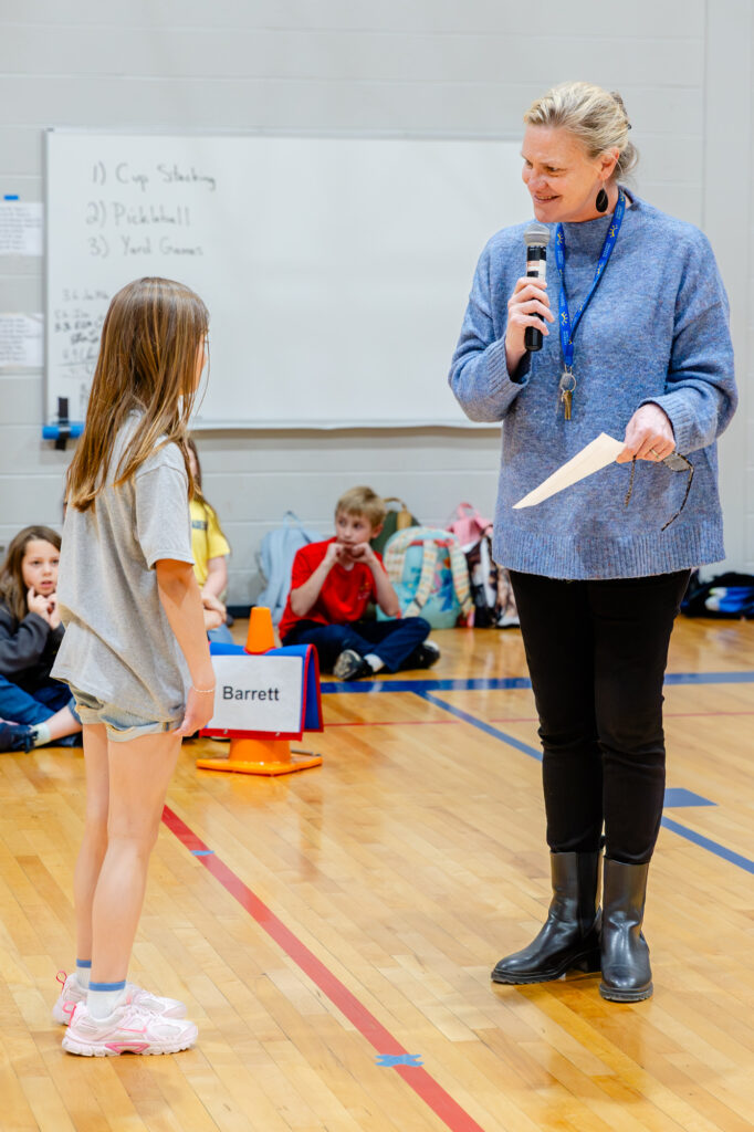 Staff member supporting a student during a classroom activity at Horizon Academy.