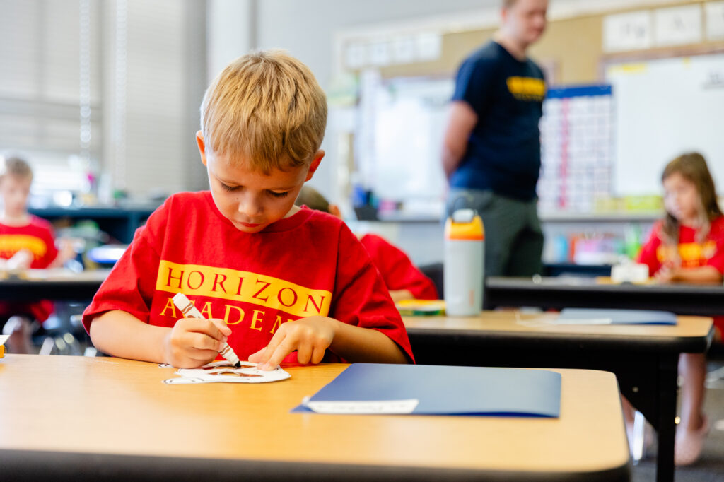 Student working independently on a classroom learning activity during a summer program.