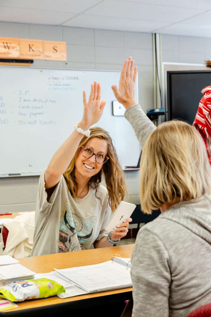 Educators raising hands during a teacher training workshop.