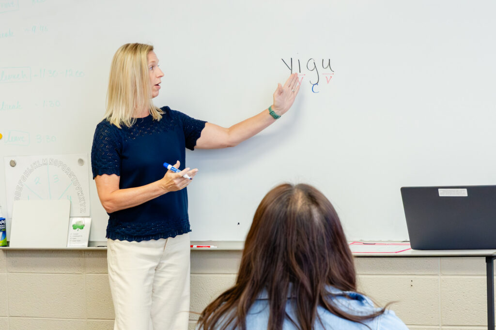 Instructor leading a teacher training session at a whiteboard.