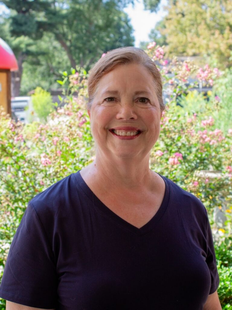Linda Cummings smiling outdoors near a campus building at Horizon Academy.