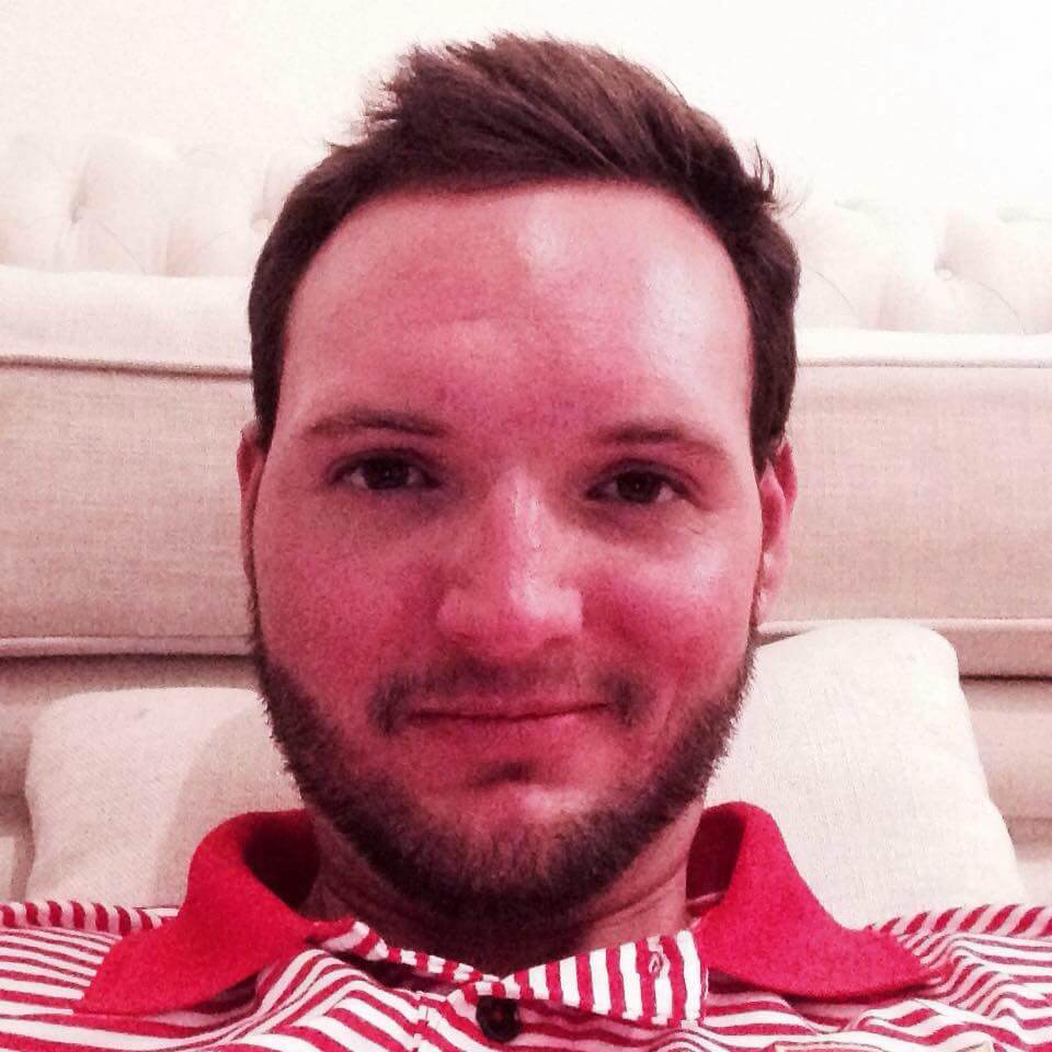 Young man in white and red striped shirt on a couch.