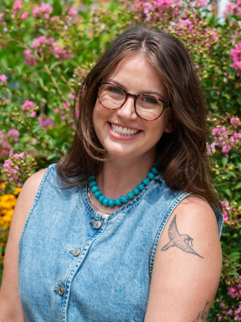 Staff member pictured in front of flower bushes on the Horizon Academy campus.
