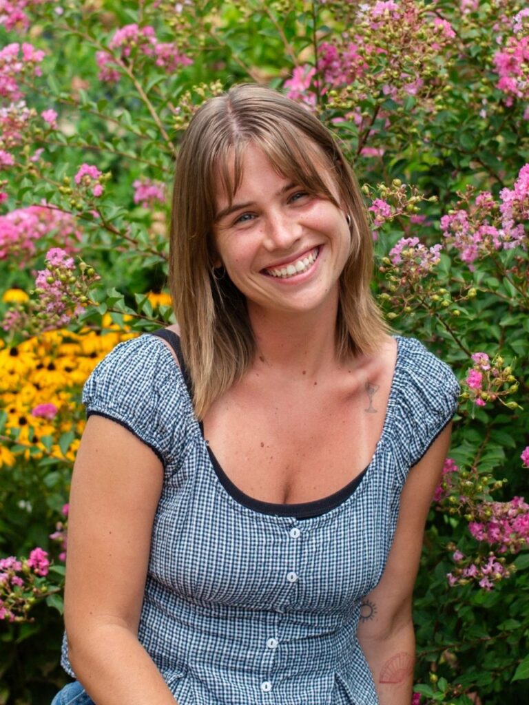 Staff member pictured in front of flower bushes on the Horizon Academy campus.