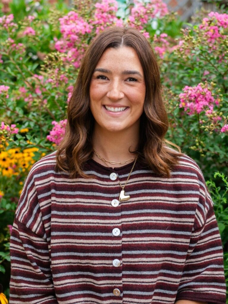 Staff member pictured in front of flower bushes on the Horizon Academy campus.