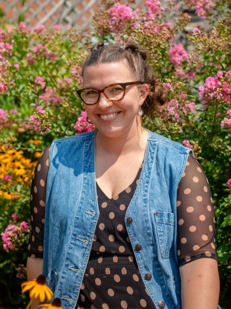 Staff member pictured in front of flower bushes on the Horizon Academy campus.