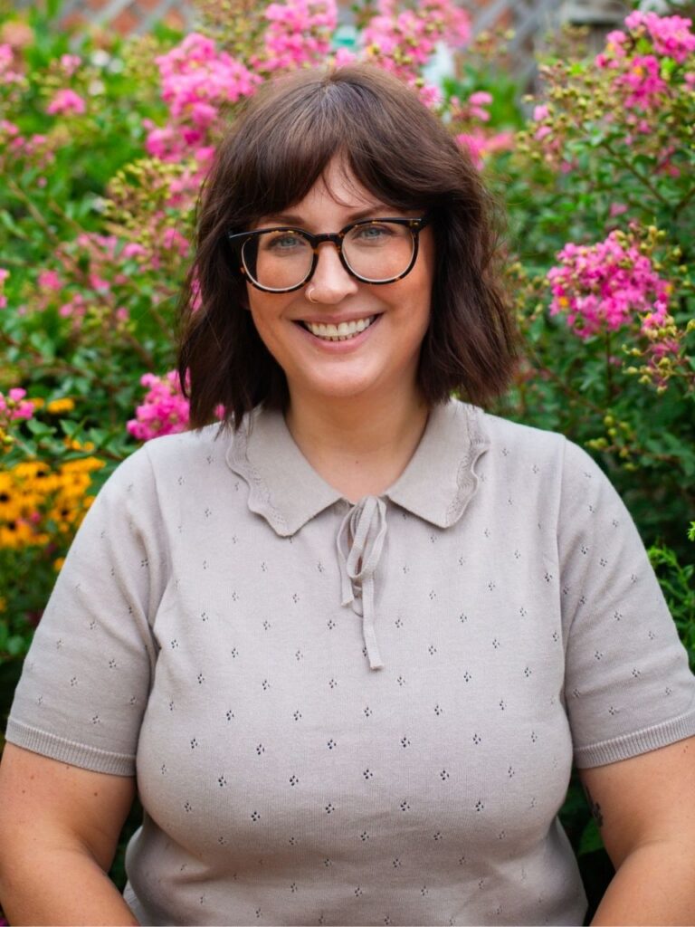 Staff member pictured in front of flower bushes on the Horizon Academy campus.