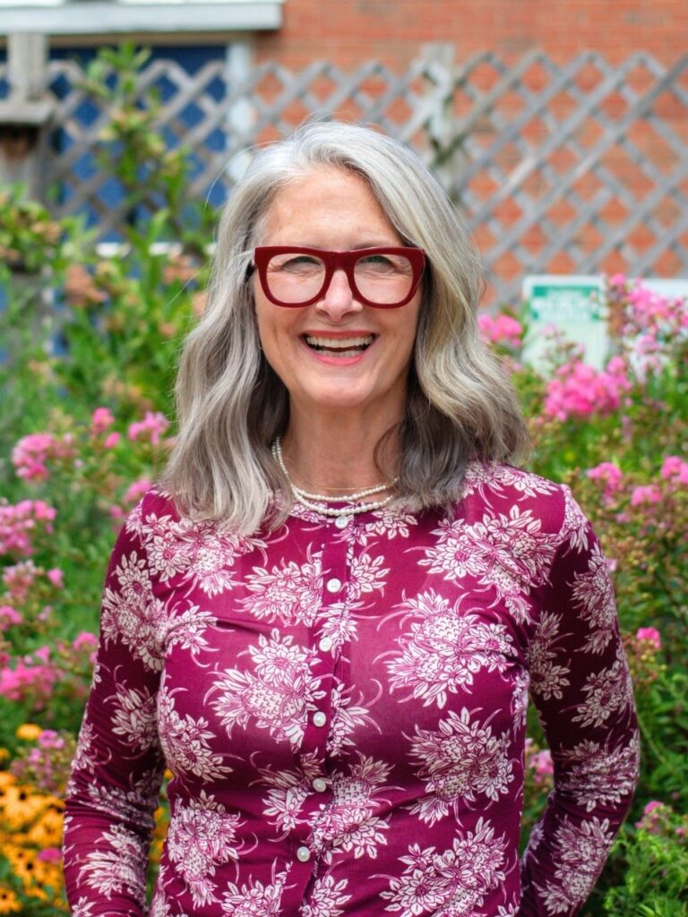 Staff member pictured in front of flower bushes on the Horizon Academy campus.