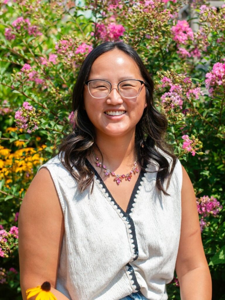 Staff member pictured in front of flower bushes on the Horizon Academy campus.