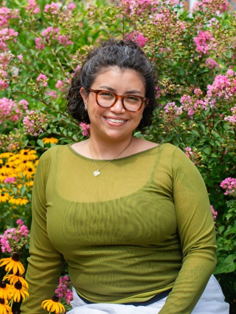 Staff member pictured in front of flower bushes on the Horizon Academy campus.