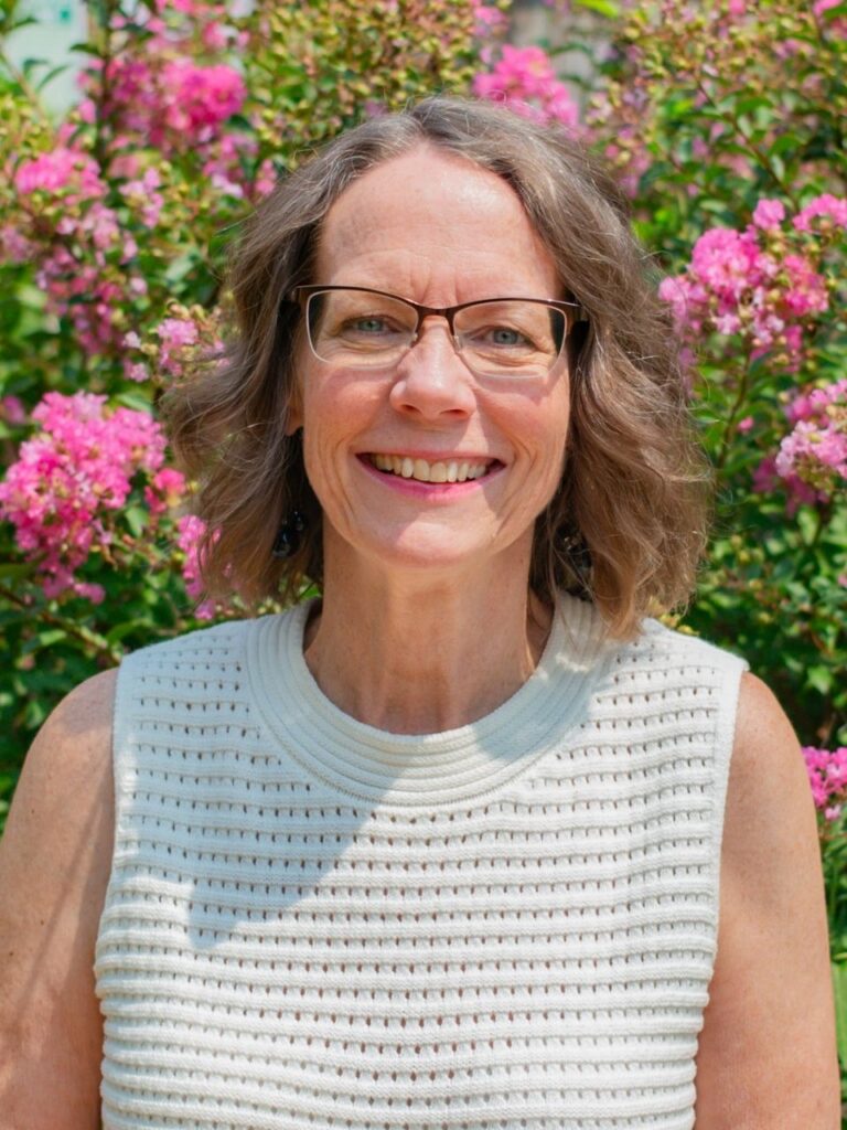 Staff member pictured in front of flower bushes on the Horizon Academy campus.