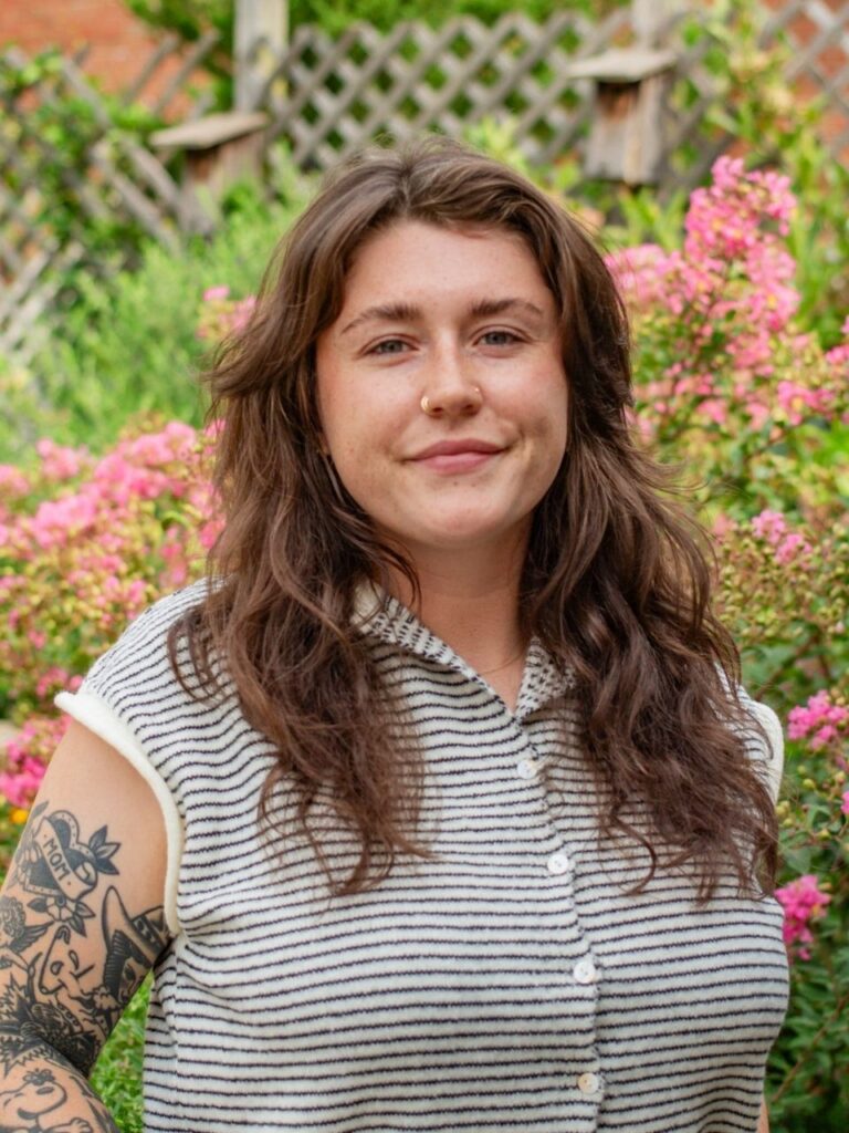 Staff member pictured in front of flower bushes on the Horizon Academy campus.