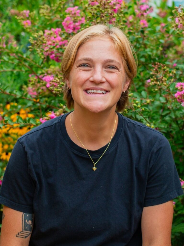 Staff member pictured in front of flower bushes on the Horizon Academy campus.