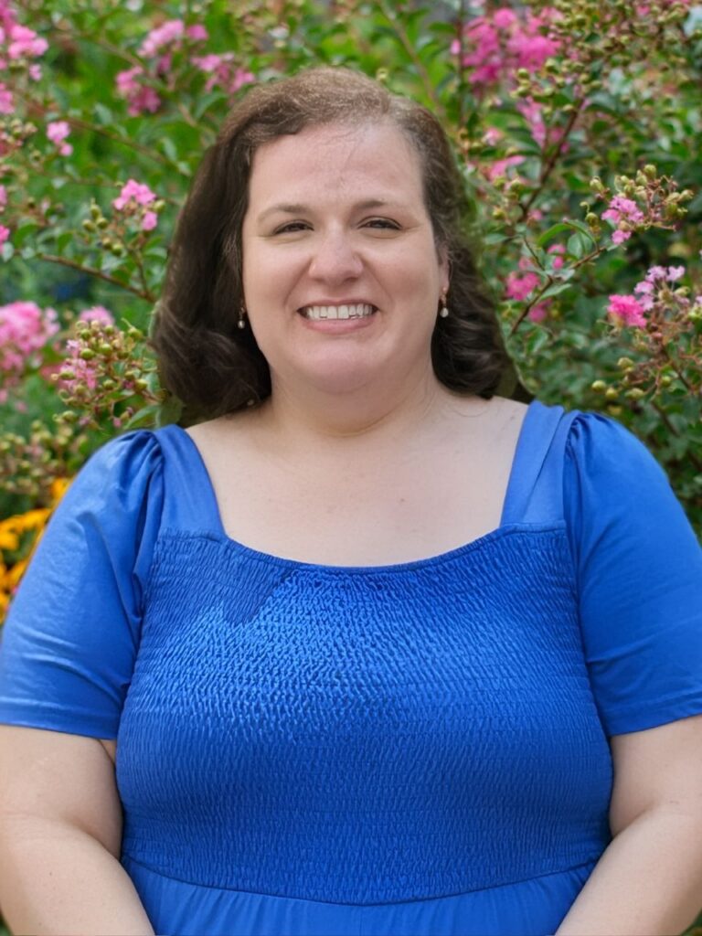 Staff member pictured in front of flower bushes on the Horizon Academy campus.