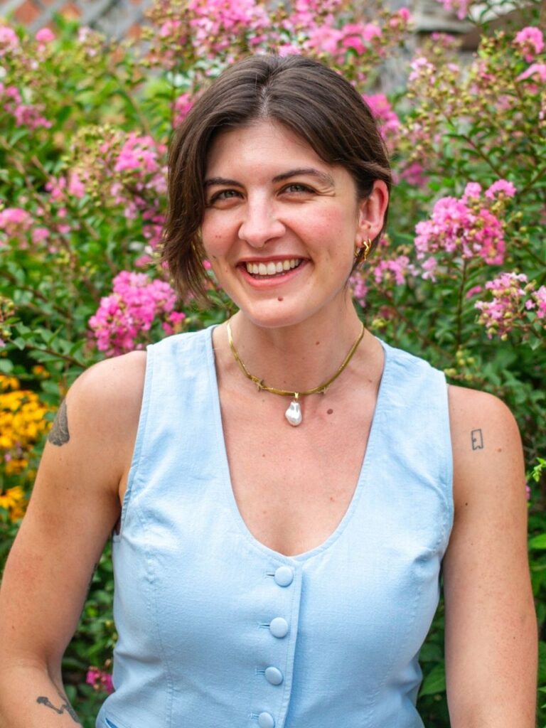 Staff member pictured in front of flower bushes on the Horizon Academy campus.