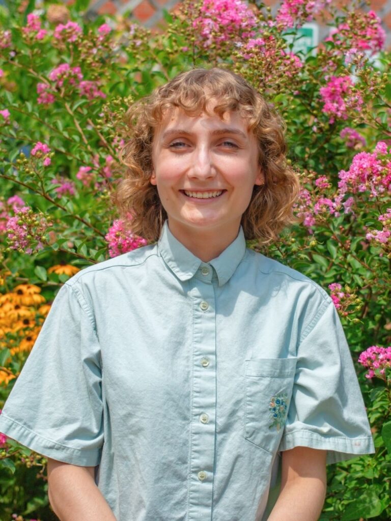 Staff member pictured in front of flower bushes on the Horizon Academy campus.