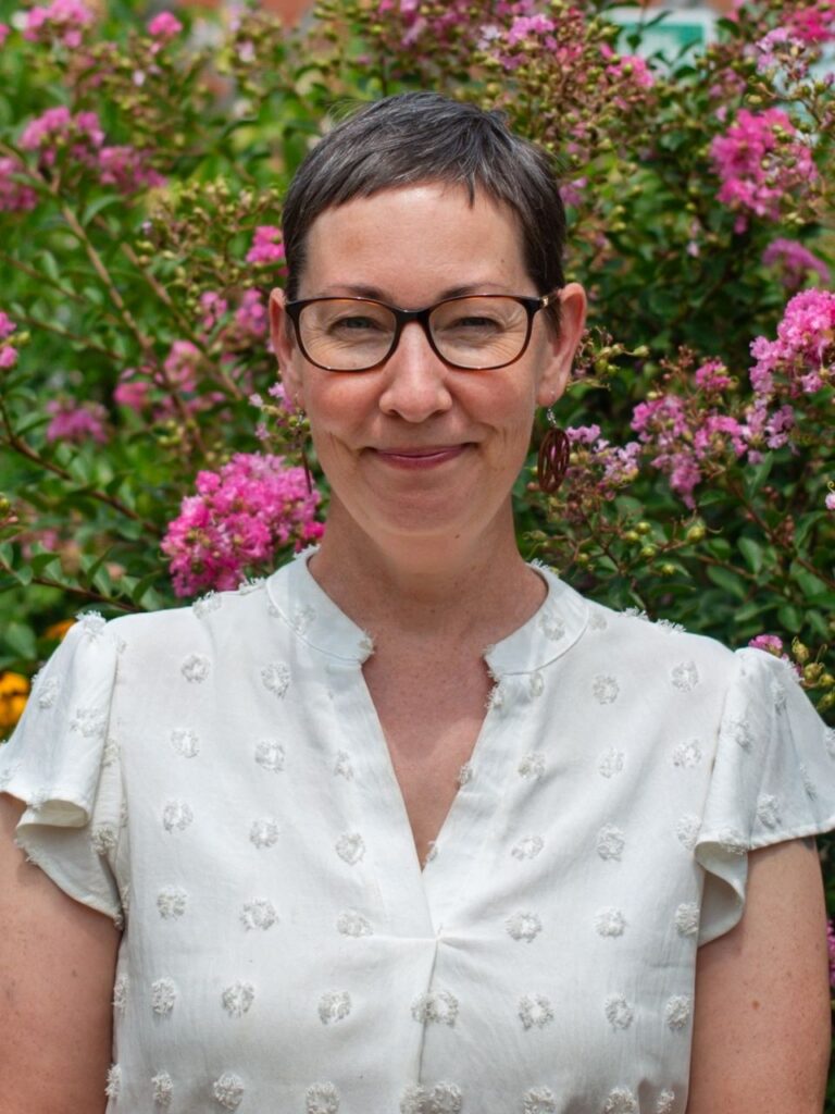 Staff member pictured in front of flower bushes on the Horizon Academy campus.