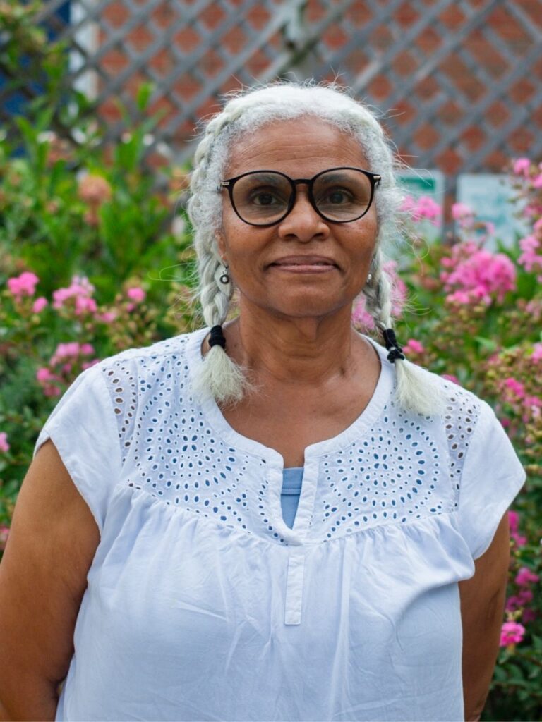 Staff member pictured in front of flower bushes on the Horizon Academy campus.