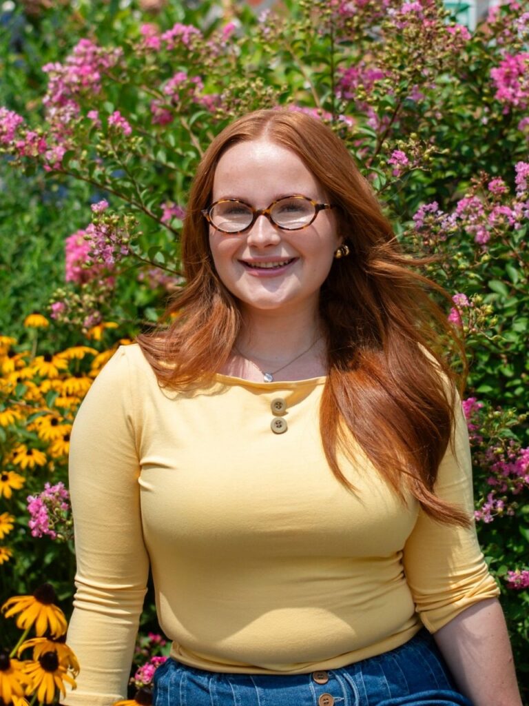 Staff member pictured in front of flower bushes on the Horizon Academy campus.