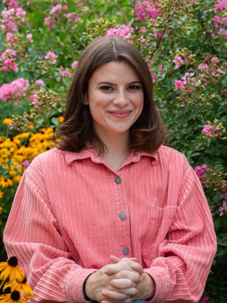 Staff member pictured in front of flower bushes on the Horizon Academy campus.