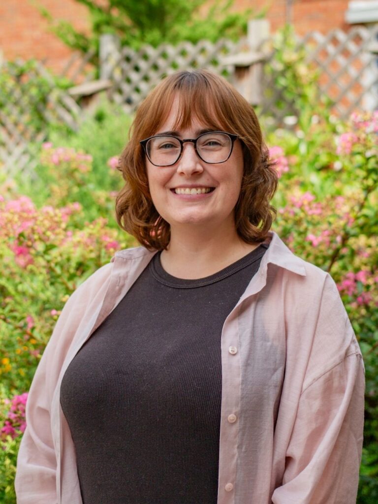 Staff member pictured in front of flower bushes on the Horizon Academy campus.